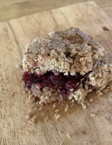 Picture of blacberry crumble bars with a layer of blackberries in the middle made using a delicious blackberry crumble bar recipe.